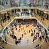 Radio waves spreading out from a mobile phone in a shopping mall with matrix style data layered on top.